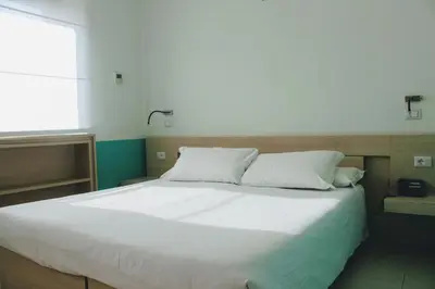 a bedroom with a large white bed with a window at Domus Helena in Rome