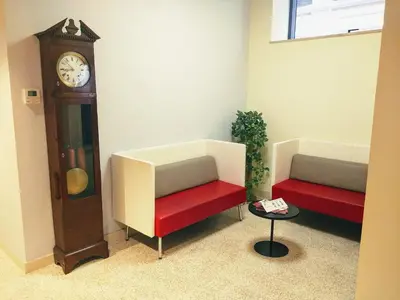 a room with two chairs and a grandfather clock at Domus Helena in Rome