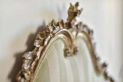 a mirror with a gold frame on a wall at B&B Casa Angelini in Rome