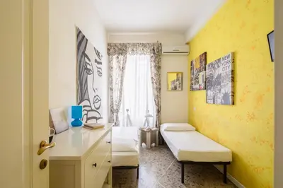 a bedroom with yellow walls and a desk and a window at B&B Anturium in Rome