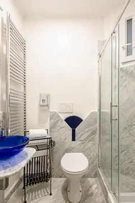 a bathroom with a toilet and a glass shower at B&B Anturium in Rome