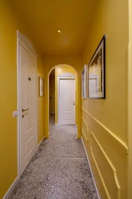 a hallway with yellow walls and a white door at B&B Anturium in Rome