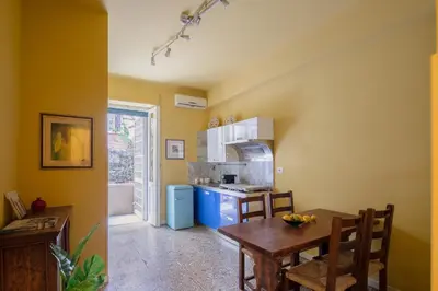 a kitchen with yellow walls and a table and chairs at B&B Anturium in Rome