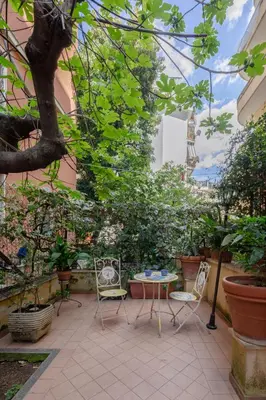 a patio with a table and chairs and the eiffel tower at B&B Anturium in Rome
