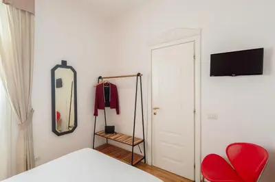 a bedroom with a bed and a mirror and a chair at B&B Anturium in Rome