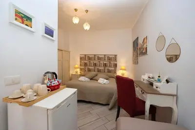 a small room with a bed and a desk and a desk at Sivory Rome in Rome