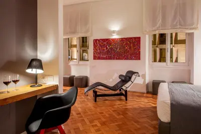 a hotel room with a chair and a bed at Belli36rooms near Spanish step and Vatican City in Rome
