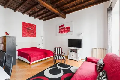 a living room with a red bed and a red couch at World Wide Bed Piazza del Popolo in Rome