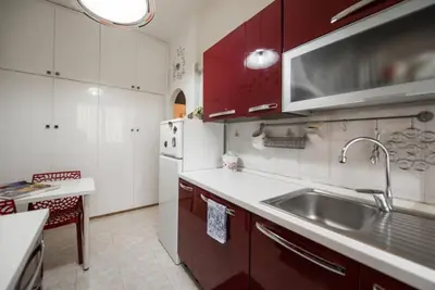 a kitchen with red cabinets and a sink at Modern Living San Paolo - Vicino alla Metro in Rome