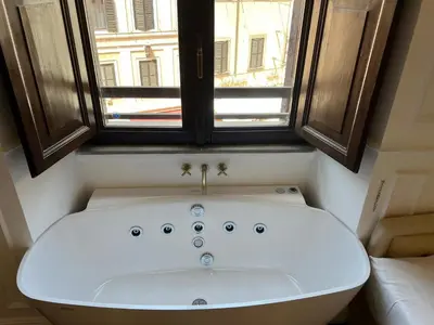 a white bath tub in a bathroom with a window at Navona Central Suites in Rome