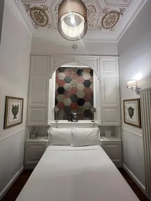 a bedroom with a white bed with a window at Navona Central Suites in Rome
