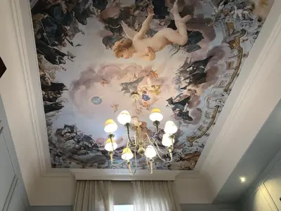 a ceiling with a painting on it with a chandelier at Navona Central Suites in Rome