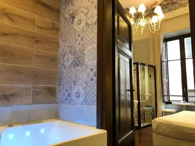 a bathroom with a bath tub and a bedroom at Navona Central Suites in Rome