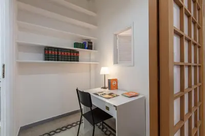 a desk with a chair next to a wall with shelves at MamaR Apartment in Rome