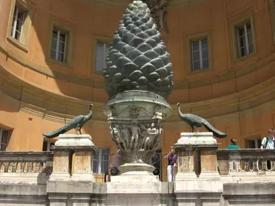 a pineapple statue in front of a building with two birds at Viale del Colosseo in Rome