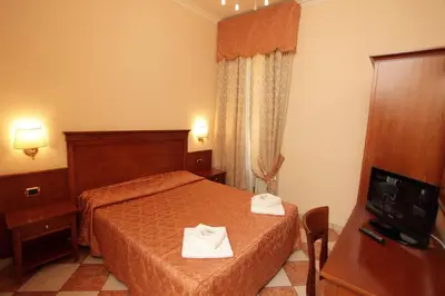 a hotel room with two beds and a television at Elegance in Rome