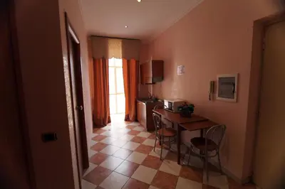 a room with a table and chairs and a kitchen at Elegance in Rome