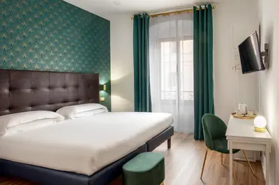 a bedroom with a large bed and a green wall at Amalia Suites by Remember Rome in Rome