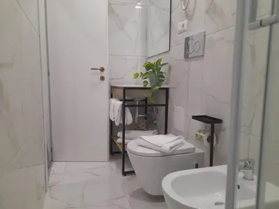 a white bathroom with a toilet and a sink at Amalia Suites by Remember Rome in Rome