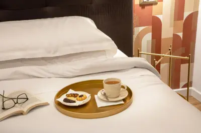 a tray of food and a cup of coffee on a bed at Amalia Suites by Remember Rome in Rome