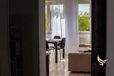 a living room with a table and a window at Mr Brown Home and suites in Rome