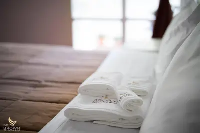 two folded towels are sitting on a bed at Mr Brown Home and suites in Rome