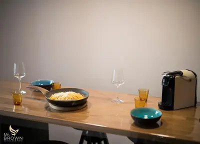 a table with a bowl of food and two wine glasses at Mr Brown Home and suites in Rome