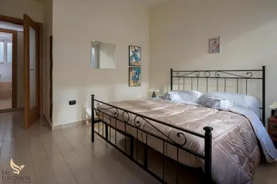 a bedroom with a large bed with a metal frame at Mr Brown Home and suites in Rome