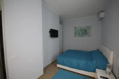 a small bedroom with a blue bed and a tv at Sweet Monte Verde in Rome