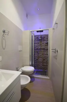 a bathroom with two toilets and a shower with a window at Sweet Monte Verde in Rome