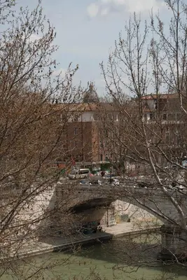 a bridge over a river with a building in the background at Over The Tiber Loft in Rome