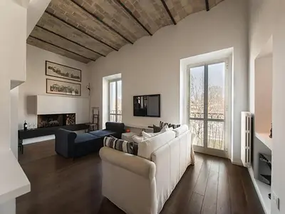 a living room with a white couch and a tv at Over The Tiber Loft in Rome