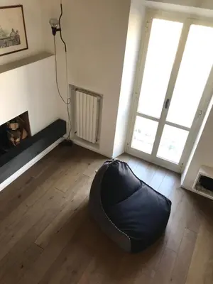 a room with a black bean bag chair in a room with a fireplace at Over The Tiber Loft in Rome