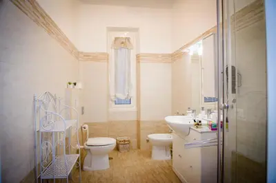 a white bathroom with a toilet and a sink at Mondo Antico in Rome