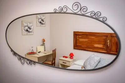 a mirror reflecting a bedroom with a bed and a desk at Mondo Antico in Rome