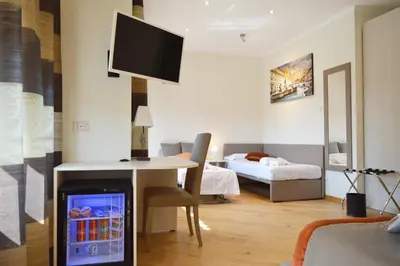 a living room with a desk with a tv and a bedroom at Vatican City Relais in Rome
