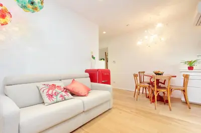 a living room with a white couch and a table at Colosseum Stylish Apartment in Rome