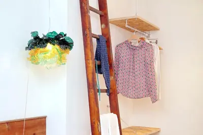 a ladder and a shirt hanging on a wall at Colosseum Stylish Apartment in Rome