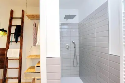 a bathroom with a shower with white tiles at Colosseum Stylish Apartment in Rome