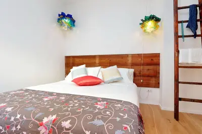 a bedroom with a bed with white sheets and red pillows at Colosseum Stylish Apartment in Rome