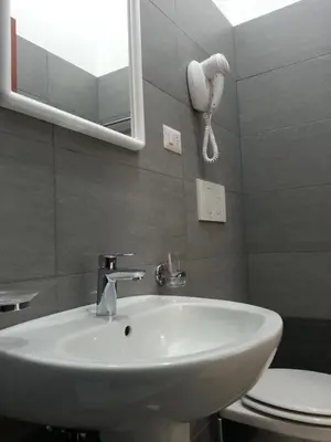 a bathroom with a sink and a mirror and a toilet at Marziah Inn in Rome