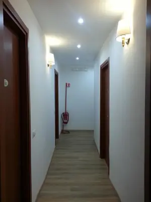 a corridor of a hallway with white walls and wooden floors at Marziah Inn in Rome