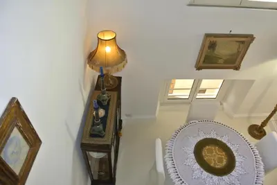 a stairway with a table and a lamp and a clock at Pantheon Domus Valentino in Rome