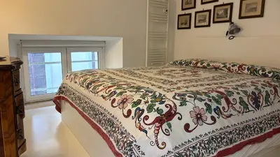 a bedroom with a bed with a flowered blanket on it at Pantheon Domus Valentino in Rome