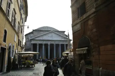a group of people walking down a street with a building at Pantheon Domus Valentino in Rome