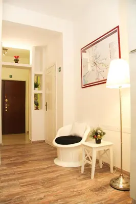 a living room with a white chair and a lamp at Maison Velia in Rome