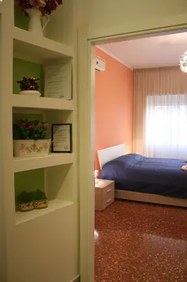 a bedroom with a bed and a window and shelves at Maison Velia in Rome