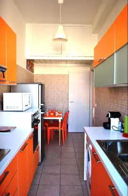 a kitchen with orange cabinets and a table in it at Granny's House Colosseum in Rome