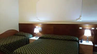 a hotel room with a bed and two lamps at Rosetta in Rome