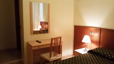 a bedroom with a bed and a desk with a lamp at Rosetta in Rome
